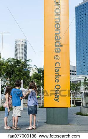Stock Photo - Singapore, Children looking at map while sightseeing in city. Fotosearch