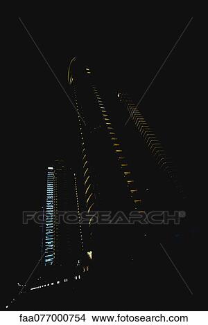 Skyscrapers illuminated at night View Large Photo Image Picture - Skyscrapers illuminated at night. Fotosearch
