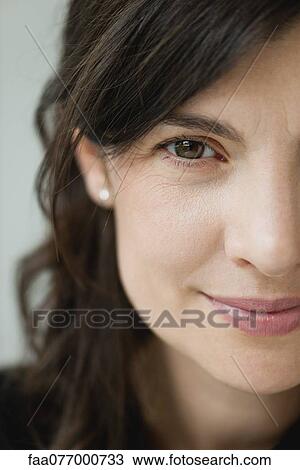 Stock Image - Smiling mid-adult woman, cropped portrait. Fotosearch