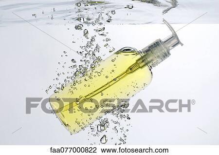 Stock Image - Soap dispenser submerged in water. Fotosearch