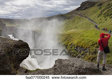 Tourist standing at edge of Gullfoss waterfall, Iceland View Large Photo Image Stock Photography - Tourist standing at edge of Gullfoss waterfall, Iceland. Fotosearch