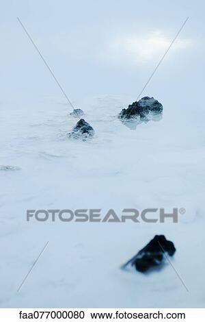 Stock Image - Volcanic rocks in Blue Lagoon, Reykjanes Peninsula, Iceland. Fotosearch
