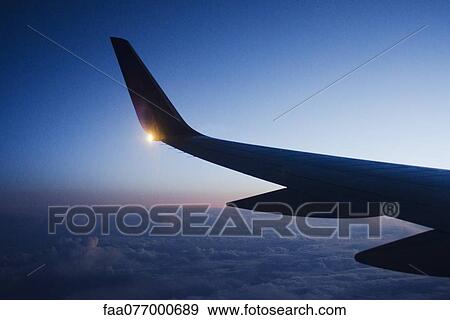 Wing of airplane in flight at dusk View Large Photo Image Stock Photo - Wing of airplane in flight at dusk. Fotosearch