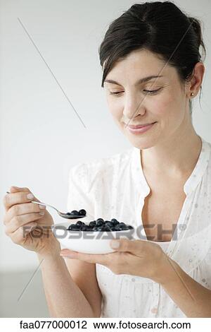 Woman eating bowl of fresh blueberries View Large Photo Image Stock Image - Woman eating bowl of fresh blueberries. Fotosearch