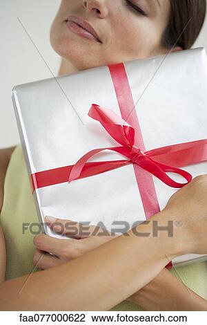 Woman embracing gift View Large Photo Image Stock Image - Woman embracing gift. Fotosearch