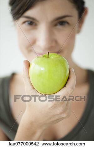 Stock Image - Woman holding apple. Fotosearch