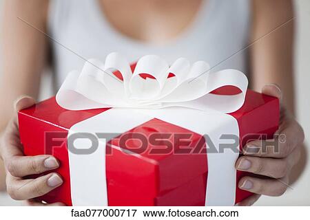 Stock Photo - Woman holding gift box, cropped. Fotosearch