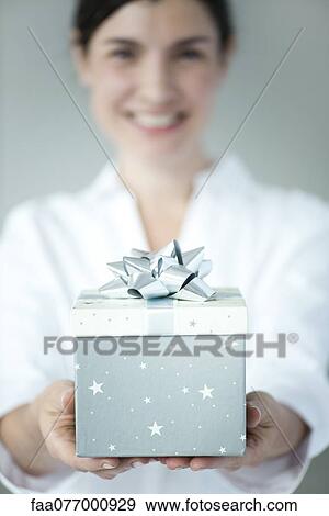 Woman holding gift box, focus on foreground View Large Photo Image Stock Photo - Woman holding gift box, focus on foreground. Fotosearch