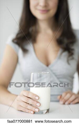 Stock Image - Woman holding glass of milk. Fotosearch
