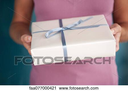 Woman holding out wrapped gift, cropped View Large Photo Image Stock Image - Woman holding out wrapped gift, cropped. Fotosearch