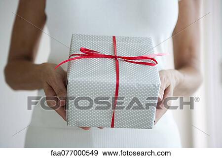 Woman holding out wrapped gift, cropped View Large Photo Image Stock Photo - Woman holding out wrapped gift, cropped. Fotosearch