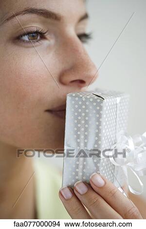 Picture - Woman kissing wrapped gift. Fotosearch