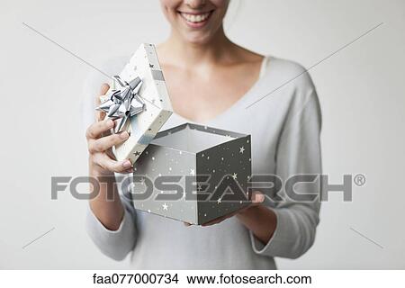Picture - Woman opening gift box, cropped. Fotosearch