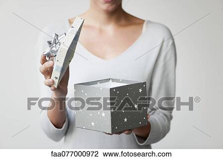 Stock Image - Woman opening gift box, cropped. Fotosearch