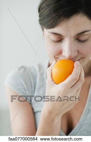 Picture - Woman smelling fresh orange. Fotosearch