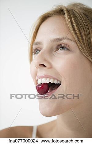 Young woman eating cherry View Large Photo Image Picture - Young woman eating cherry. Fotosearch