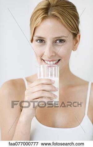 Stock Photo - Young woman holding glass of milk. Fotosearch