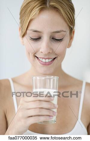 Stock Photography - Young woman holding glass of milk. Fotosearch