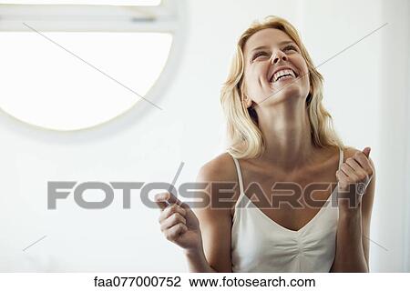 Young woman holding pregnancy test, laughing View Large Photo Image Stock Image - Young woman holding pregnancy test, laughing. Fotosearch