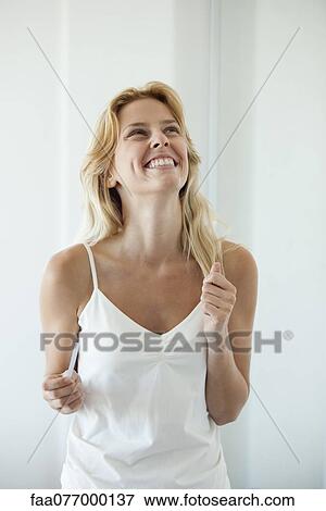 Stock Photo - Young woman holding pregnancy test, laughing. Fotosearch