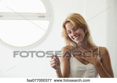 Young woman looking at pregnancy test, smiling View Large Photo Image Stock Photo - Young woman looking at pregnancy test, smiling. Fotosearch