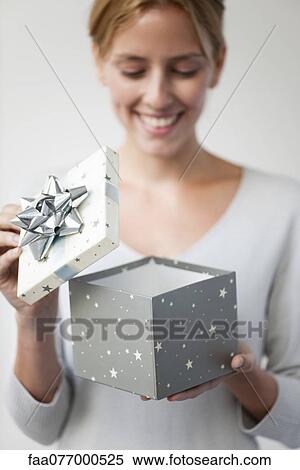 Stock Photography - Young woman opening gift box. Fotosearch