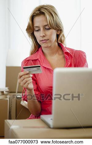 Stock Image - Young woman shopping online for her new home. Fotosearch