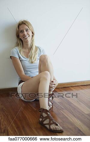 Young woman sitting on hardwood floor View Large Photo Image Stock Photograph - Young woman sitting on hardwood floor. Fotosearch