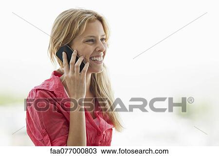 Stock Image - Young woman talking on cell phone. Fotosearch