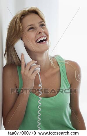 Young woman talking on landline phone, laughing View Large Photo Image Stock Photo - Young woman talking on landline phone, laughing. Fotosearch