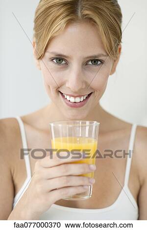 Young woman with glass of orange juice, portrait View Large Photo Image Stock Image - Young woman with glass of orange juice, portrait. Fotosearch