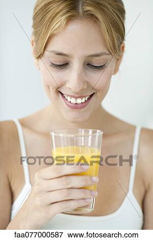 Stock Photo - Young woman with glass of orange juice. Fotosearch