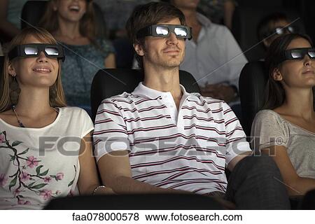 Stock Photo - Audience enjoying 3-D movie in theater. Fotosearch