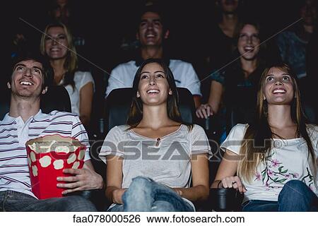 Stock Photograph - Audience watching movie in theater. Fotosearch