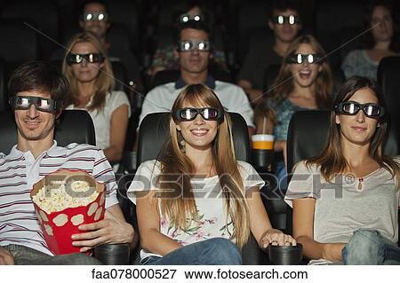Stock Photo - Audience wearing 3-D glasses in movie theater. Fotosearch