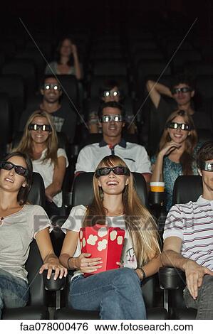 Stock Photograph - Audience wearing 3-D glasses in movie theater. Fotosearch