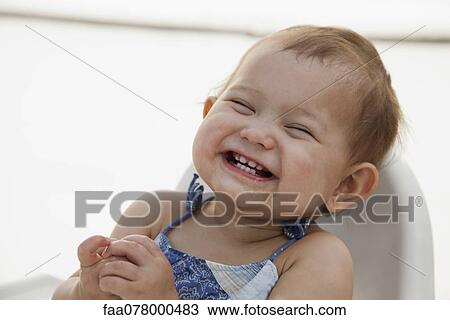 Stock Image - Baby girl laughing, portrait. Fotosearch