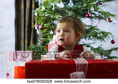 Stock Photo - Baby girl opening Christmas present. Fotosearch