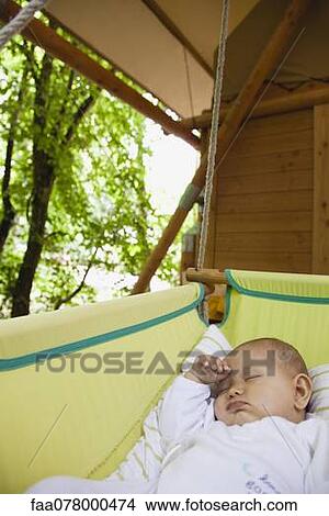 Picture - Baby napping in cradle outdoors. Fotosearch