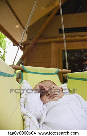Picture - Baby napping in cradle outdoors. Fotosearch