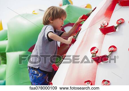 Stock Photo - Boy climbing on playground. Fotosearch
