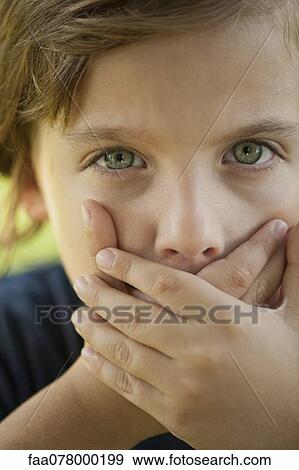 Stock Photo - Boy covering mouth with hands. Fotosearch