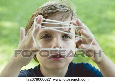 Stock Photo - Boy playing cat's cradle. Fotosearch