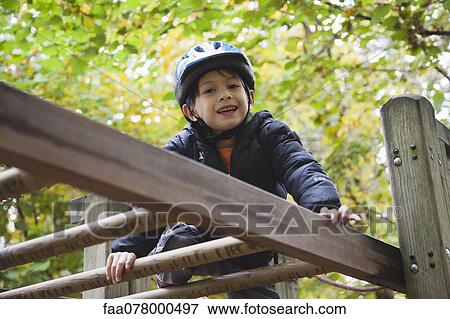 Boy playing on jungle gym View Large Photo Image Stock Photo - Boy playing on jungle gym. Fotosearch