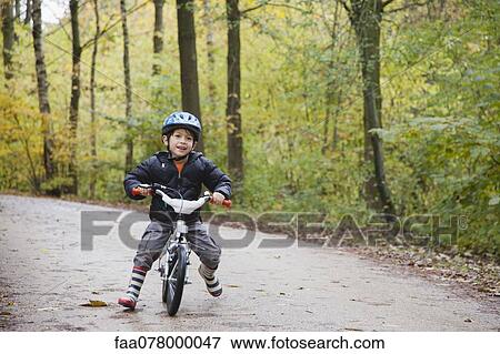 Boy riding bike, smiling at camera View Large Photo Image Stock Photo - Boy riding bike, smiling at camera. Fotosearch