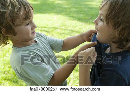 Stock Photo - Boys fighting, one gripping the other's shirt. Fotosearch