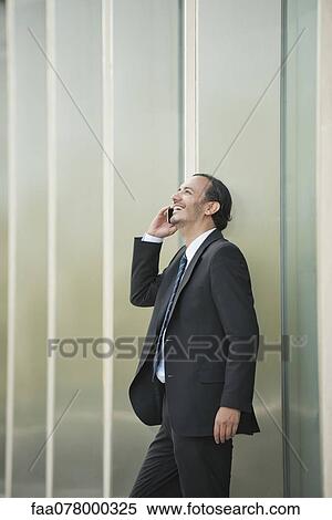 Stock Photography - Business executive using cell phone outdoors. Fotosearch