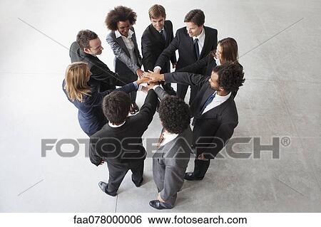 Stock Photograph - Business team members link hands in unity. Fotosearch