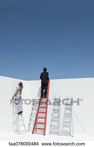 Picture - Businessman and businesswoman climbing ladders. Fotosearch