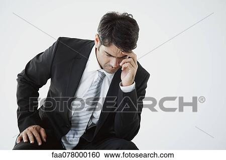 Stock Image - Businessman deep in thought facing difficulty. Fotosearch